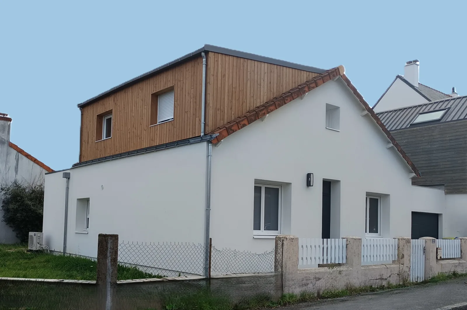 Maison rénovée : enduit blanc et extension en bardage bois